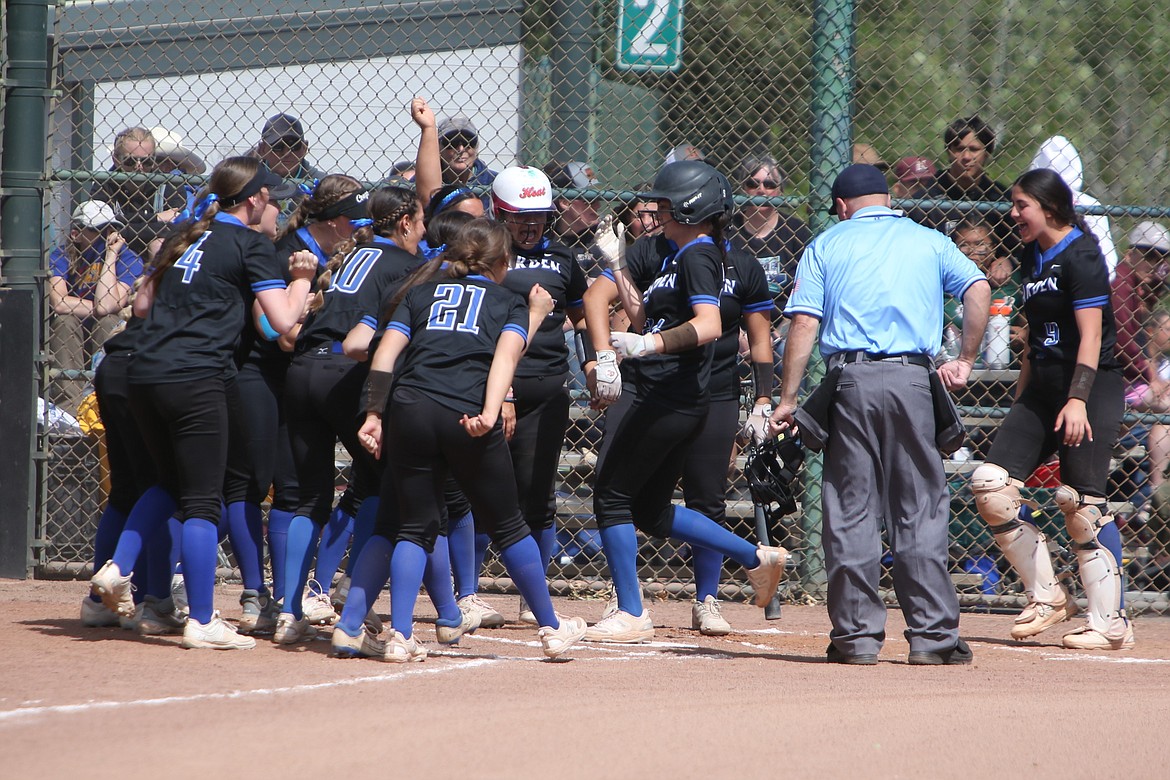 Warden players celebrate at home plate after senior Sierra Campos hit a solo home run in the top of the second inning against Adna on Saturday.