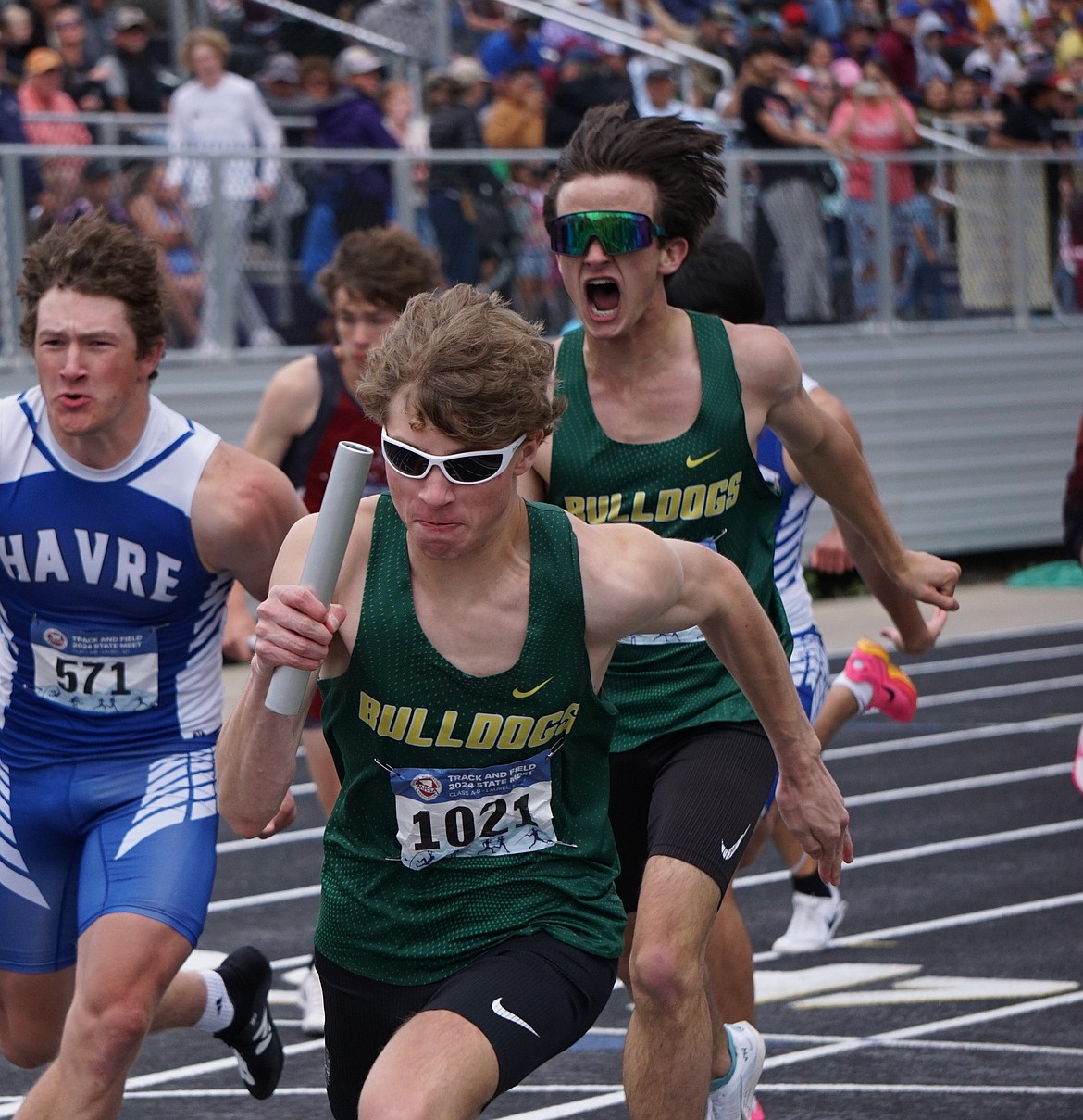 Juniors Ethan Amick (foreground) and Simon Douglas in the 4X400 relay at state. Bulldog boys squad finished second overall in the long-relay late Saturday afternoon in Laurel. (Matt Weller Photo)