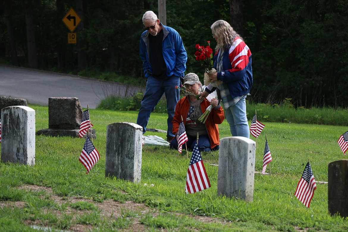 Les Campbell, Marvalee Higgins and Mo Campbell place flowers at the grave of their great-uncles, Bud McConnell and Clarence McConnell, both of whom service in the military. The trio were among a handful of family members who attended Monday's Memorial Day service at Pinecrest Cemetery.