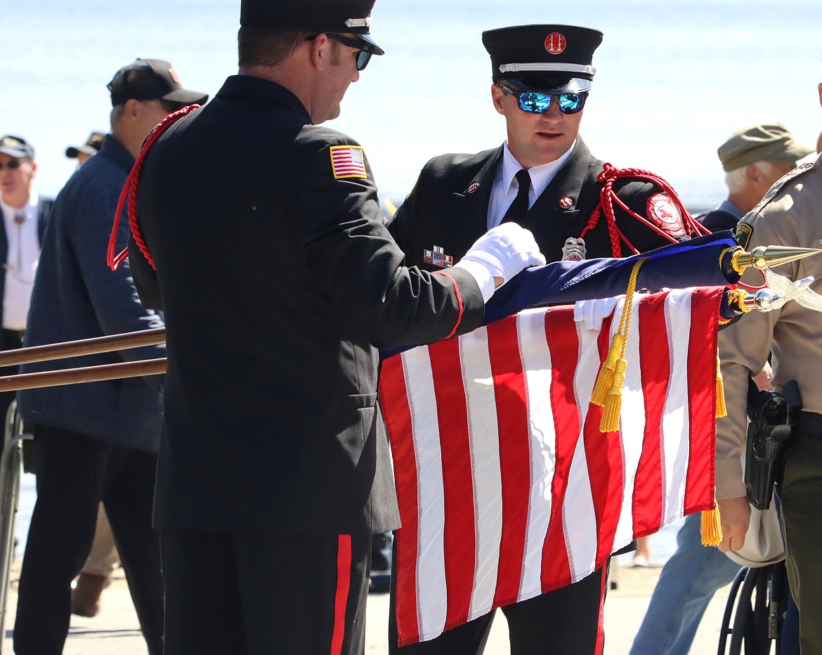 Members of the Northern Lakes Fire District put the flag away following a Memorial Ceremony at Hayden Lake.