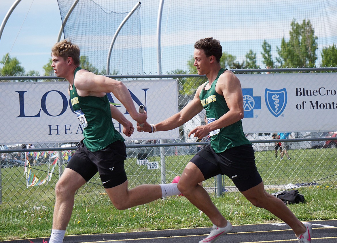 Junior Scott Dalen secures the baton from Senior Ryder Barinowski in the Men's 4X100 Relay. The team would finish the relay with a season best time of 43.54. (Matt Weller Photo)