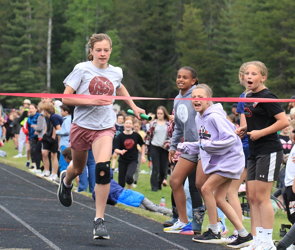 Xina Schicker, a fifth-grader at Washington Elementary, gets ready for finish the girls' 4x100 relay while being cheered on by friends.