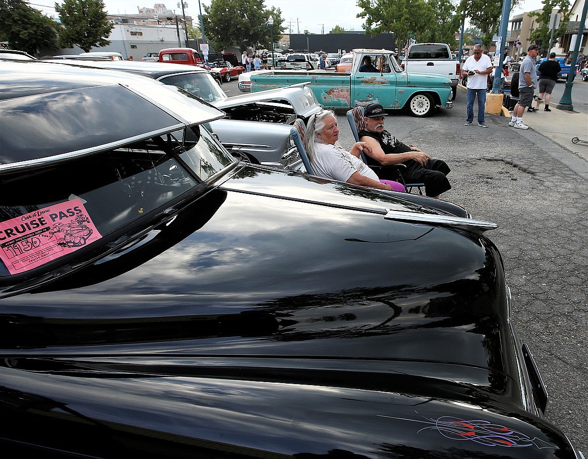 John and Patti Shaver sit near their 1950 Chevrolet Fleetline Deluxe and watch the Car d'Lane cruise Friday night.