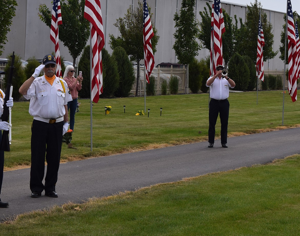 A bugler plays “Taps” while honor guard members salute during Monday’s Memorial Day observance at Quincy Valley Cemetery. The song is played at the end of the day and during military funerals.