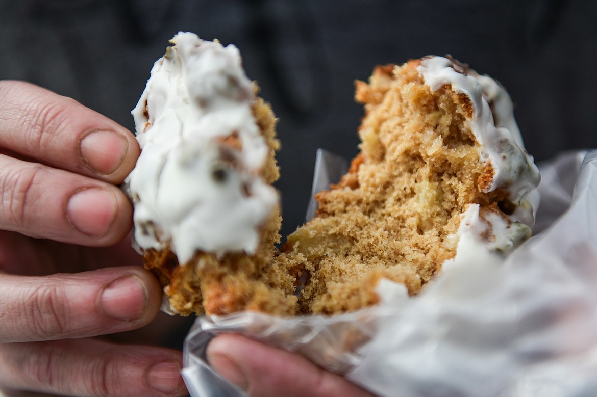 A customer breaks open an apple fritter from Big Sky Buttercakes on Wednesday, May 29. (Casey Kreider/Daily Inter Lake)