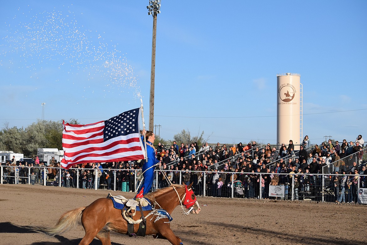 A trick rider with this year’s Last Stand Rodeo rides around the arena Saturday evening, kicking off the event by shooting sparks out of the tube holding the American flag.