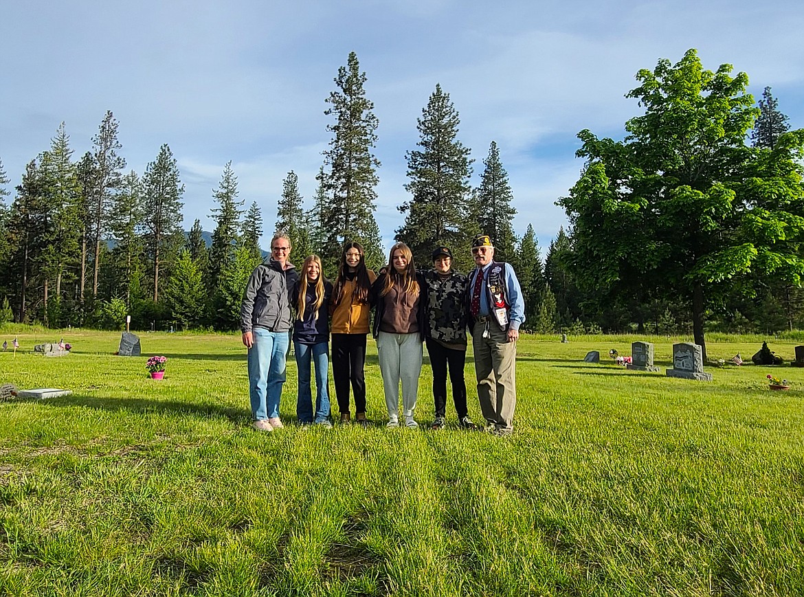 Boundary County Middle School Leadership class members stand with (right) Robert Rains, Junior Vice Commander of the American Legion Post #55 after placing flags on Veteran graves at Grandview Cemetery on Friday, May 24.