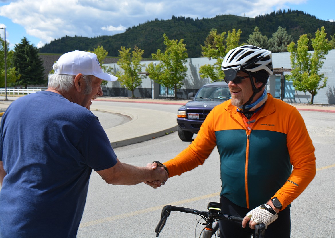 Bob Whitman of The Fuller Center in the Silver Valley welcomes Neil Mullikin on reaching Kellogg after riding his bicycle from Spokane at the start of the day. Mullikin is one of 27 riders going on a cross-country bicycle adventure to fundraise for home projects for people in need.