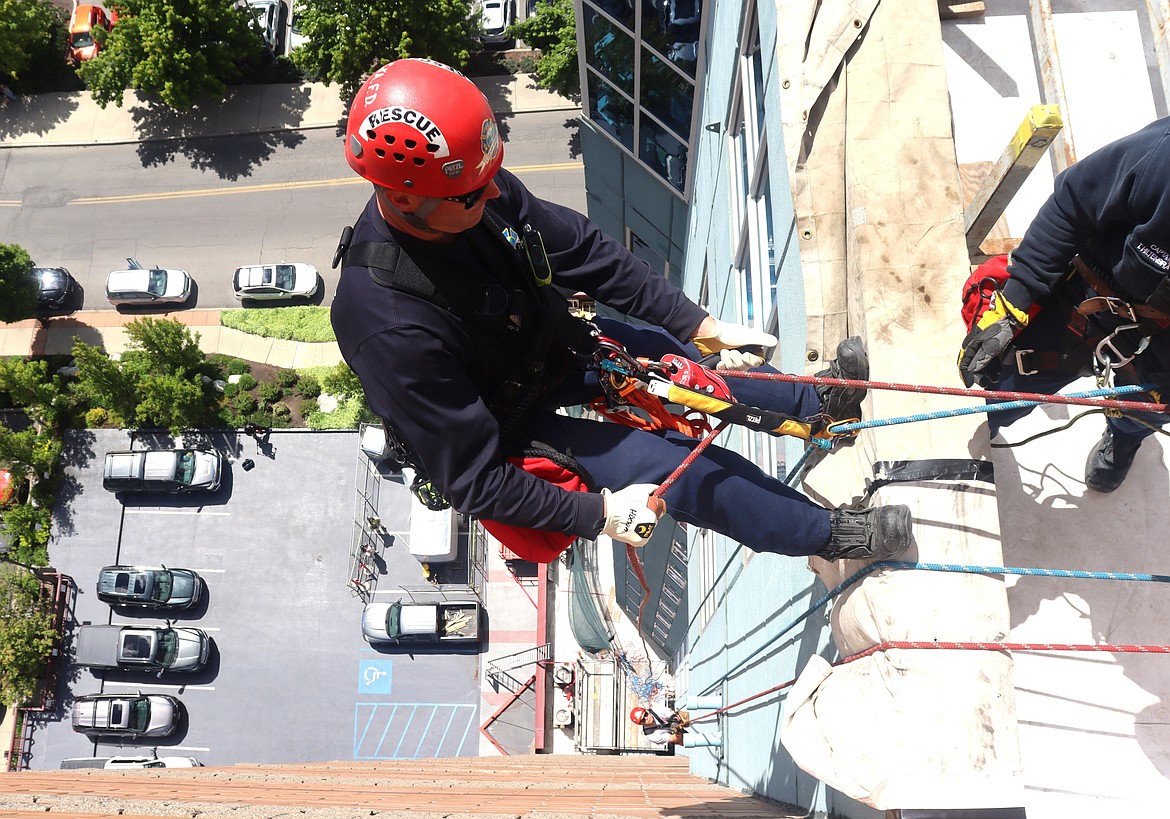 Coeur d'Alene Firefighter Travis Hixson prepares to descend the side of McEuen Terrace during rescue training on Thursday.