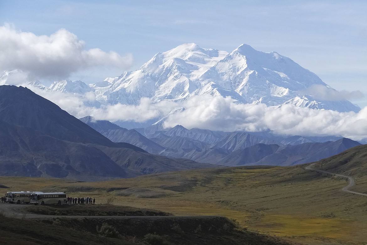 Sightseeing buses and tourists are seen at a pullout popular for taking in views of North America's tallest peak, Denali, in Denali National Park and Preserve, Alaska, Aug. 26, 2016. Two climbers awaited rescue near the peak of North America’s tallest mountain Wednesday, May 29, 2024, a day after they and a third climber in their team requested help after summiting Denali during the busiest time of the mountaineering season, officials at Denali National Park and Preserve said. (AP Photo/Becky Bohrer, File)