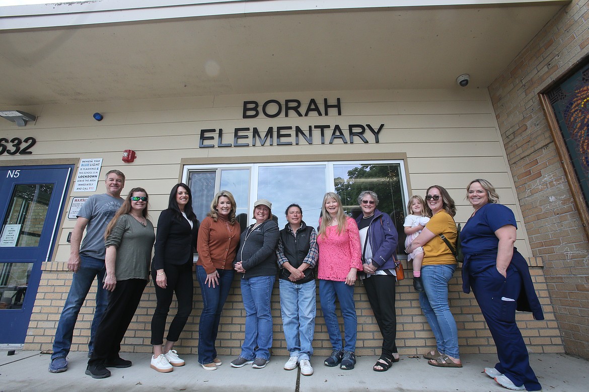 Multiple generations of former Borah Elementary students gather Tuesday outside the school to share memories and swap stories as the closure of the school is on the horizon. From left: Tom Scheller, Ginny Easterly, Lisa Aitken, Sue Espinazza, Dana Baze, Kat Yockey, Heather Cederblom, Dina Hourlland, Ashley Rohrman holding daughter Elsie Rohrman and Kim Kraack.