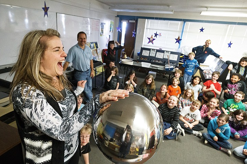 In this March 2012 photo, Jennifer Reyes, a fourth grade teacher at Borah Elementary School, reacts after shocking herself from static electricity produced by a Van de Graaff generator during a demonstration hosted by educators with the STAR Discovery Bus.