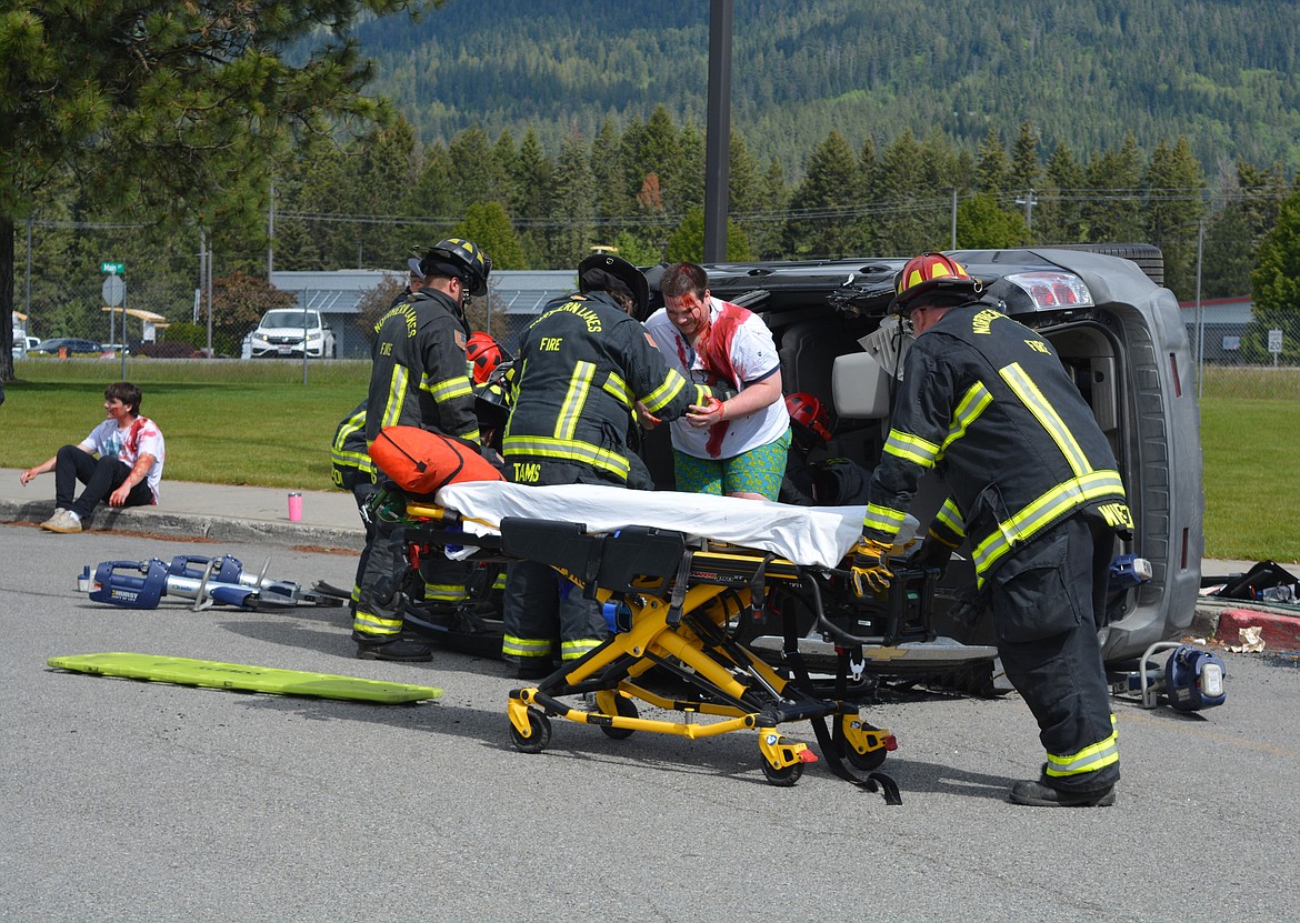 Student Liam Bradford is helped out of the vehicle by Northern Lakes firefighters after being involved in a mock crash at Lakeland High School.