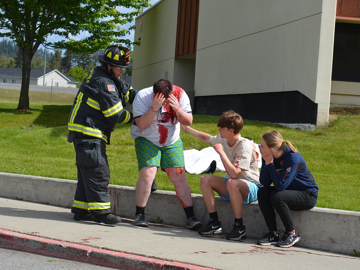 Paramedic Amanda Tams holds up Liam Bradford as he breaks down after being extricated from a vehicle at Lakeland High School during a mock crash involving fentanyl. Roan Reilly and Denise Novak try to comfort him in the wake of the simulated crash.