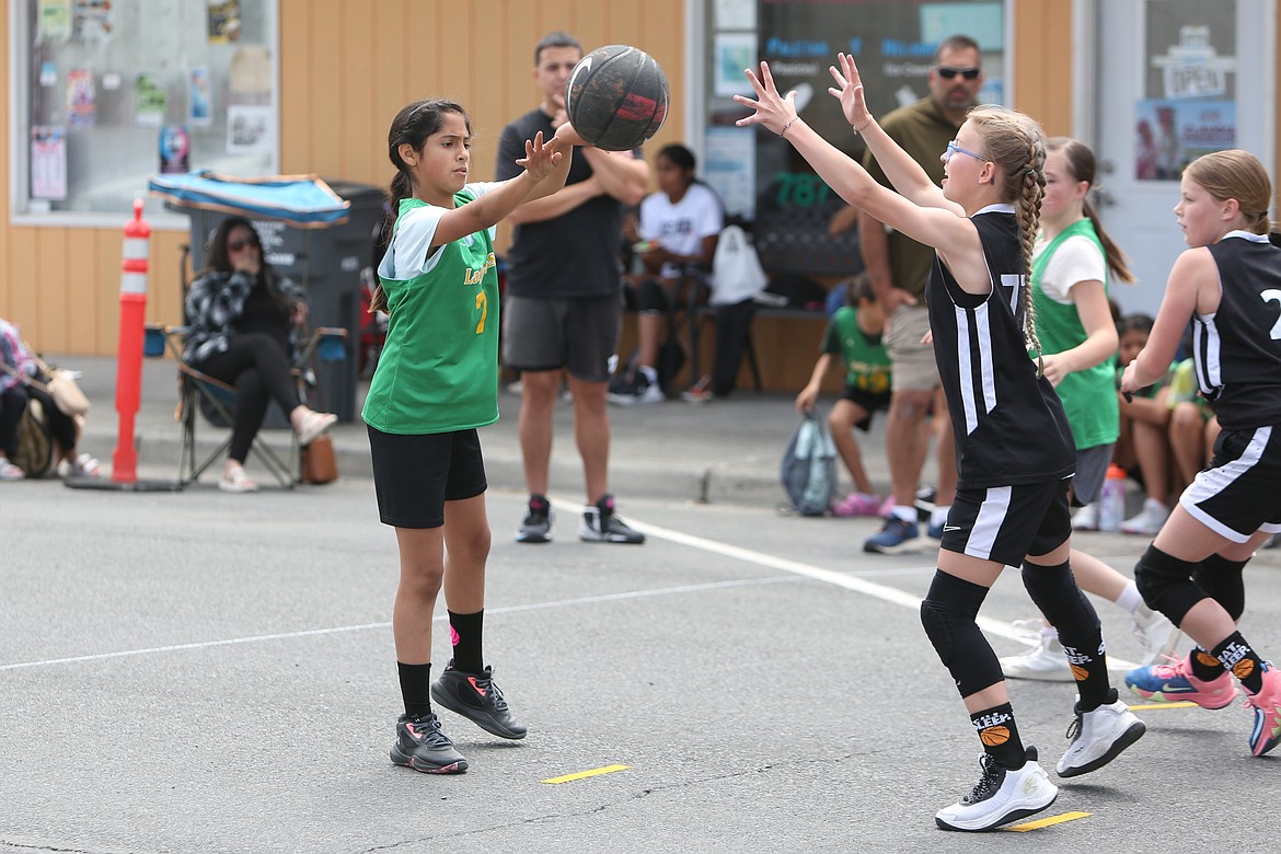 A player makes a pass while being defended at the Dru Gimlin 3-on-3 Basketball Tournament Saturday in Quincy.