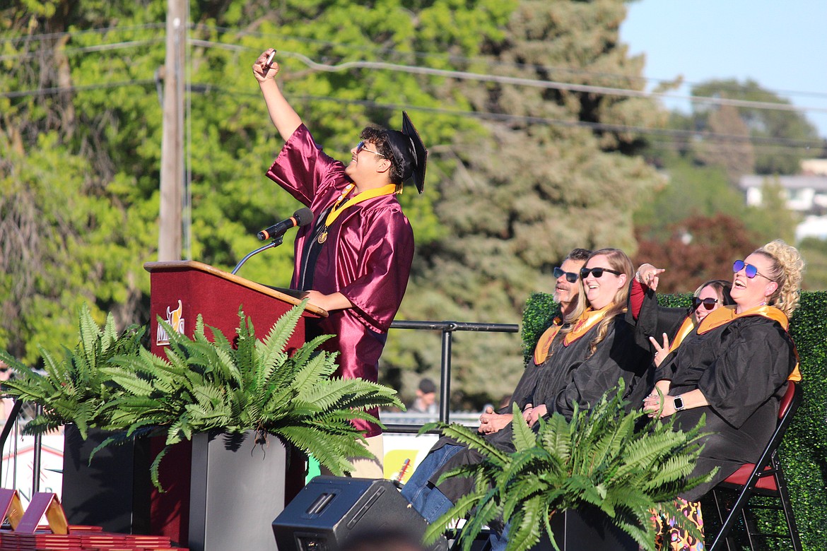 Before he gets into his speech, class speaker AJ Moreno stops to grab a selfie with the Moses Lake School Board.