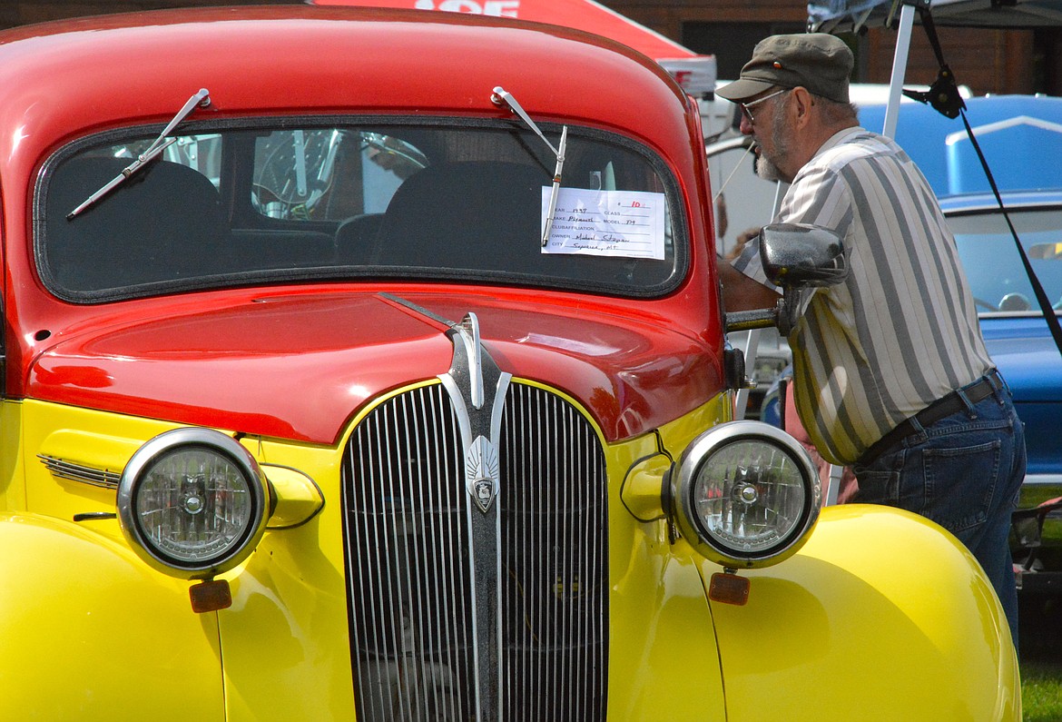 Michael Stepan, from Superior, takes a moment and peers inside his two tone 1937 Plymouth during the Old Schoolhouse Rock Car Show last Saturday. (Mineral Independent/Amy Quinlivan)