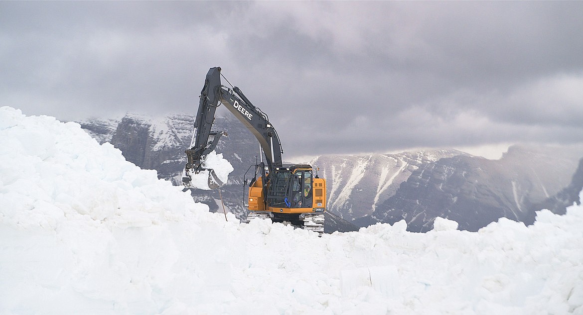 An excavator clears snow from the Going-to-the-Sun Road at Logan Pass Thursday.