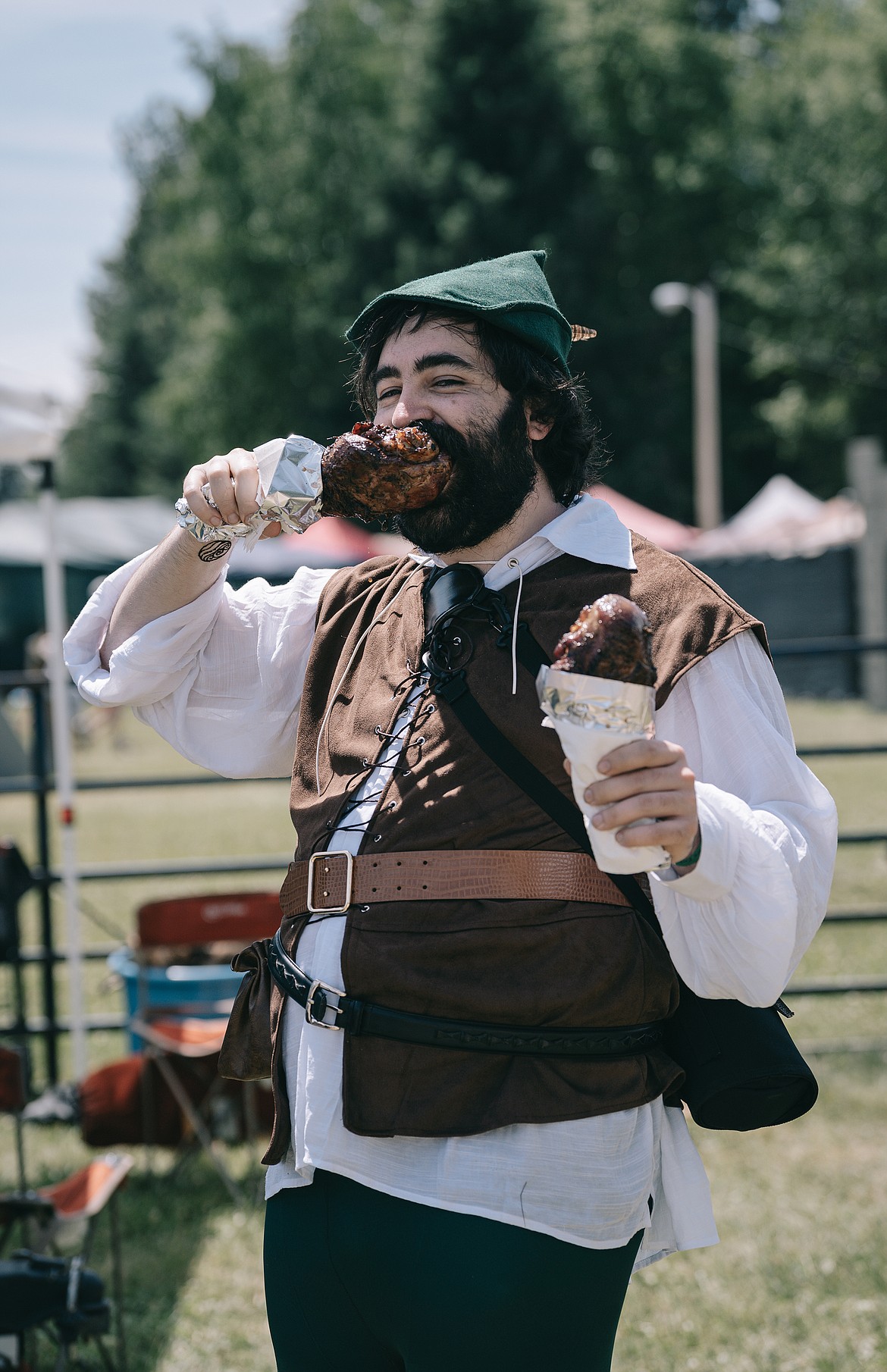 An attendee a the 2023 Sandpoint Renaissance Faire enjoys one of the event's infamous turkey legs.