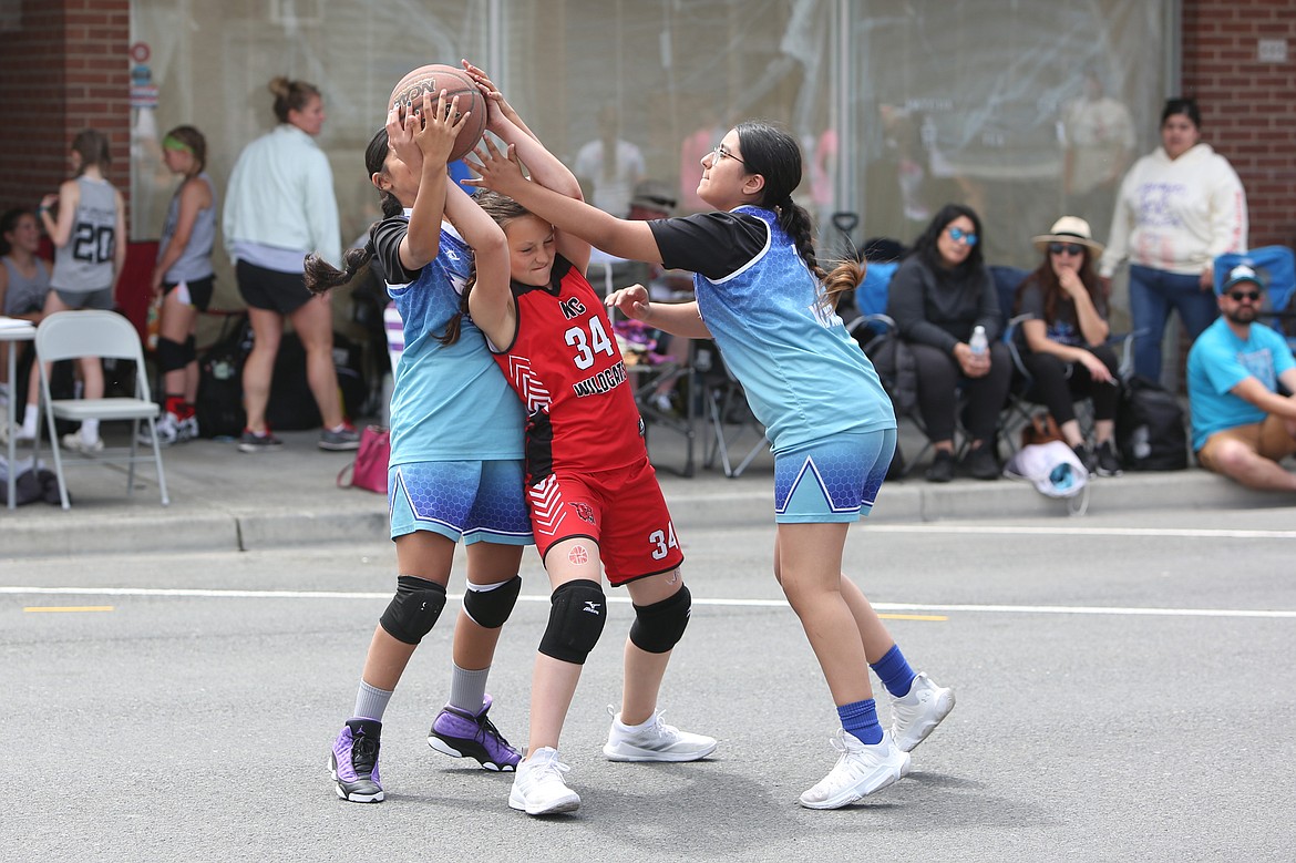 Two players attempt to steal the ball during a game at the Dru Gimlin 3-on-3 Basketball Tournament in Quincy on Saturday.