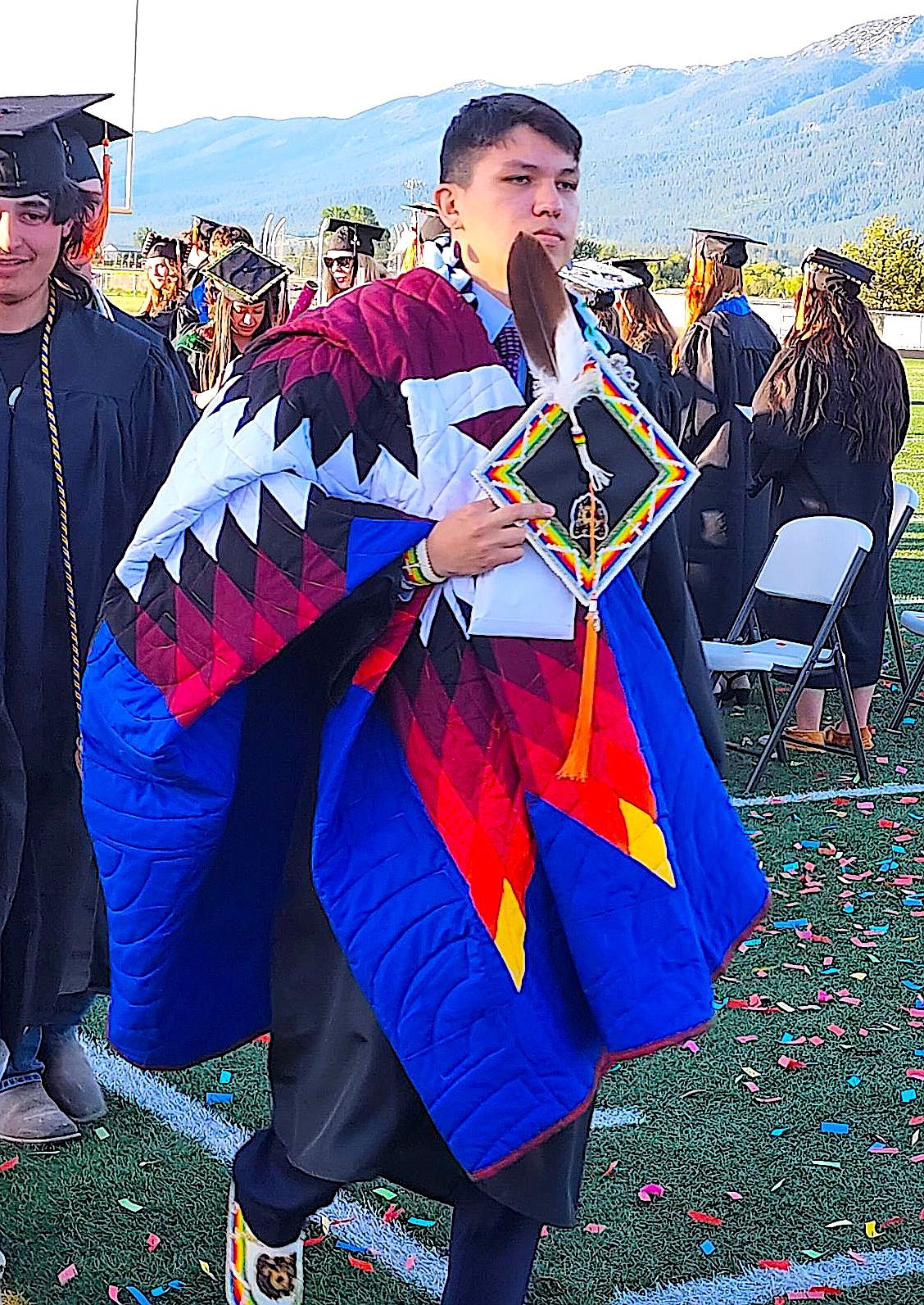 Ronan graduate Jyles Baker carried his star quilt as he and his classmates left the football field after Friday night's graduation. (Berl Tiskus/Leader)