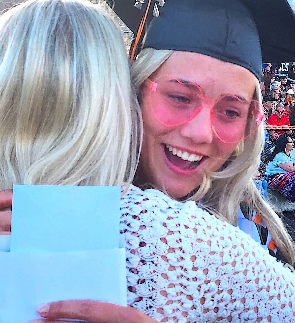 Lei Cunningham-Hoyt gives a favorite teacher a hug at Ronan graduation. (Berl Tiskus/Leader)