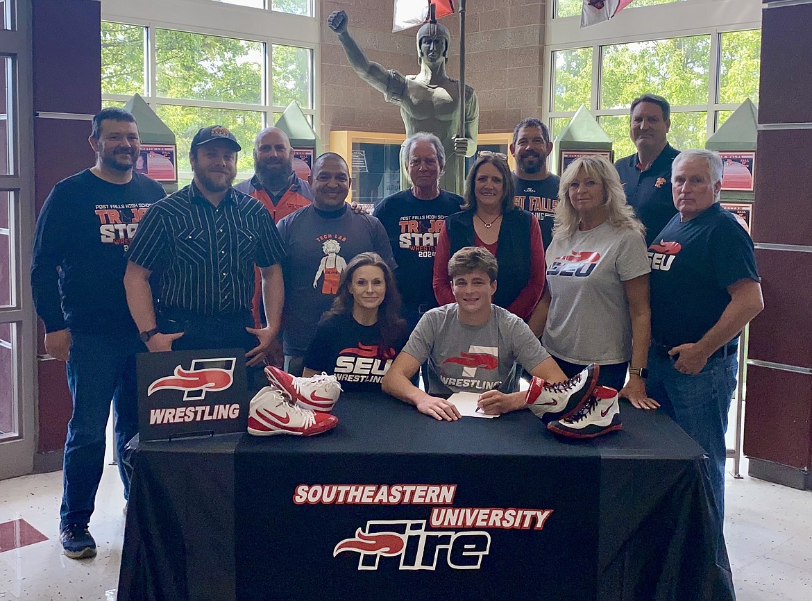 Courtesy photo
Post Falls High senior Tyson Barnhart recently signed a letter of intent to wrestle at NAIA Southeastern University in Lakeland, Fla. Seated from left are 
Tiffany Barnhart and Tyson Barnhart; second row from left, James Hammer, Abel De La Rosa, Shelly Barnhart, Rae Jean Frank and Jeff Frank; and back row from left, Jeremy Zender, Pete Reardon (Post Falls High head wrestling coach), Jeff Barnhart, Luke Roberts and Craig Christensen (Post Falls High athletic director).