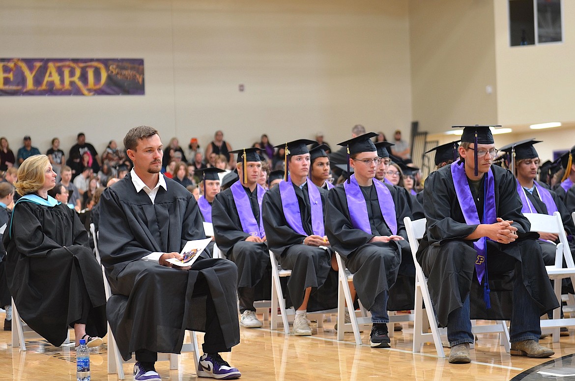 Polson's 117-member Class of 2024 appears to be contemplating their future during Saturday's commencement ceremony, alongside teachers Becky Hoxie and Carson Oakland. (Kristi Niemeyer/Leader)