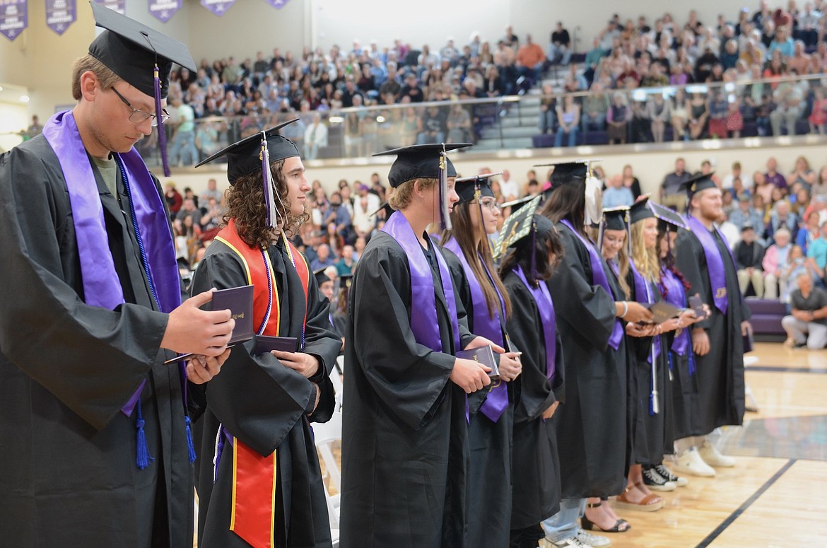 Row of freshly-minted Polson graduates checks out their diplomas. (Kristi Niemeyer/Leader)