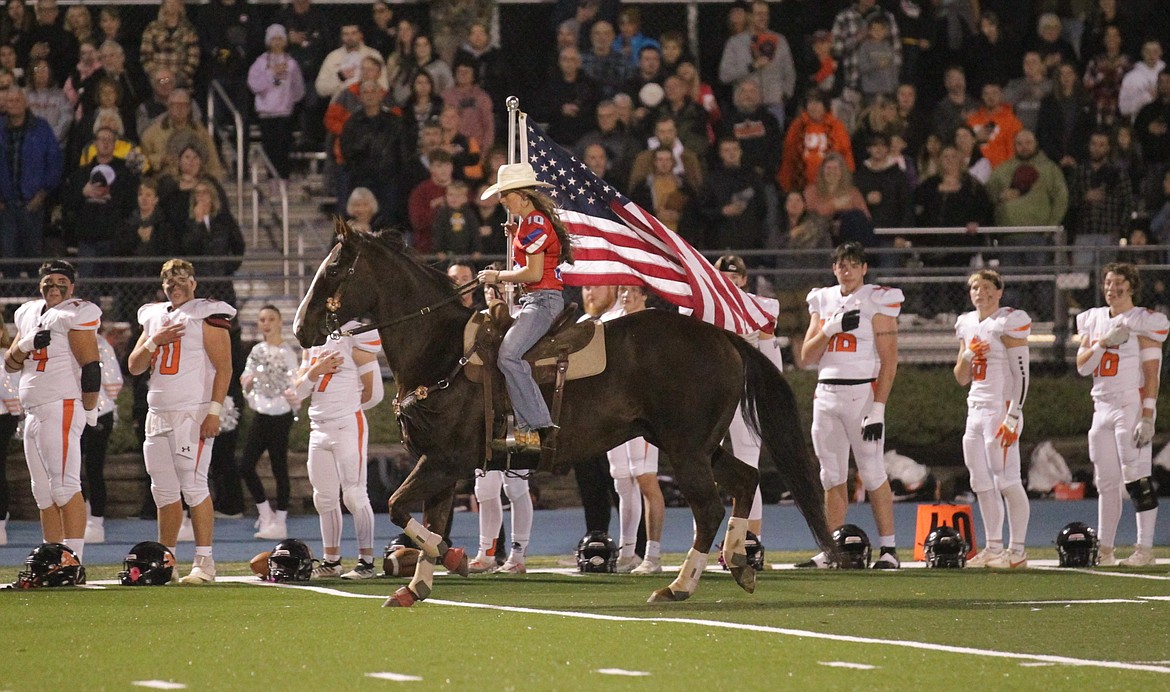 MARK NELKE/Press
Lauren Rook, and her horse Tucker, circle the field at Coeur d'Alene High with the American flag prior to the Vikings' football game vs. Post Falls on Oct. 13, 2023.