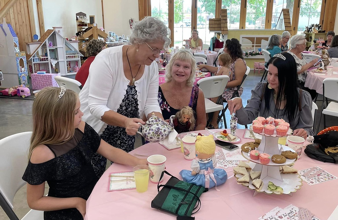 Quincy Valley Historical Society & Museum director Harriet Weber, center, pours tea during the 2023 toys through Time party. “Down on the Farm” will be the theme for 2024.