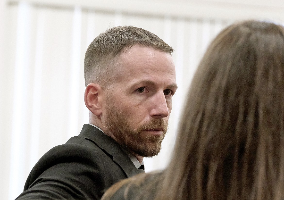 Montana Highway Patrol Trooper Lewis Johnson listens to his wife, Kate, a fellow MHP officer during the sentencing hearing Wednesday, June 5, 2024, for Jason Allen Miller in the Lincoln County Courthouse. Miller was sentenced to life without parole for attempted deliberate homicide. (Paul Sievers/The Western News)