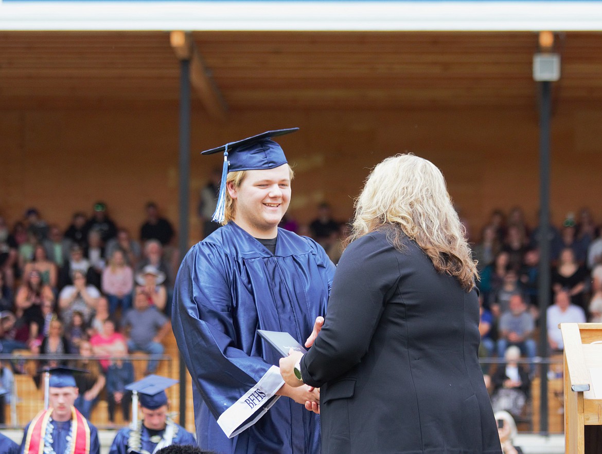 A Bonners Ferry High School graduate of the Class 2024 shakes hands with BCSD Superintendent Jan Bayer at graduation on June 1.