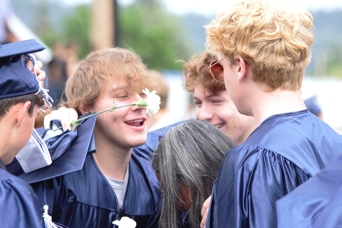 Graduates laugh after graduation.