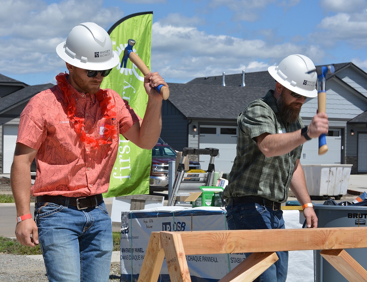Kyle Shuey and Brian Orr of Hayden Homes compete to see who is the fastest at hammering nails during the First Story wall raising event for Sarah Reeser and her family.
Orr won the overall competition.