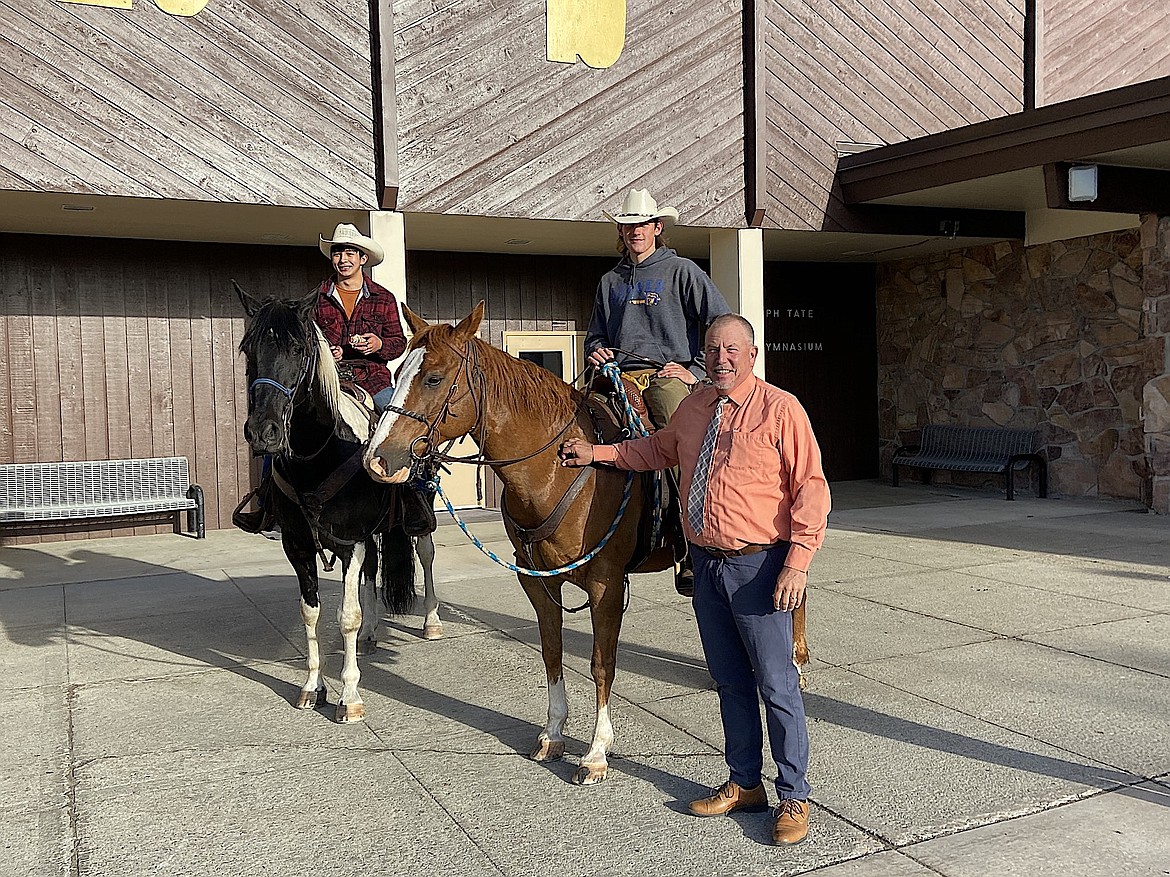 Libby High School seniors Gabe Gier and Morgan Davis rode their horses to class on the last day of school before stopping for a photo with principal Jim Germany. Morgan's mom Jennifer shared the photos of their ride with The Western News and that state law requires the principal to care for the animals during the day. Fortunately for Germany, it was a prank and the horses didn't stay. (Courtesy photo)