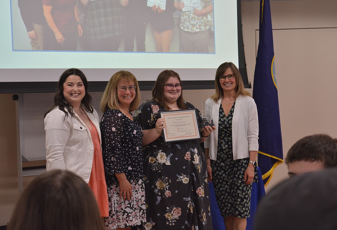 Abbie Waters, Theresa Moran, Piper Benzon and Kim Anderson pose for the camera as Benzon holds up her Project SEARCH certificate.