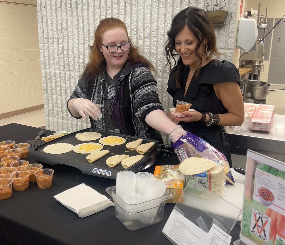 Senior Shelby Daily and University of Idaho Extension professor Shelly Johnson prepare cheese quesadillas to be served with vegetarian chili the students made from scratch Wednesday for Venture Academy’s Exhibit Night.