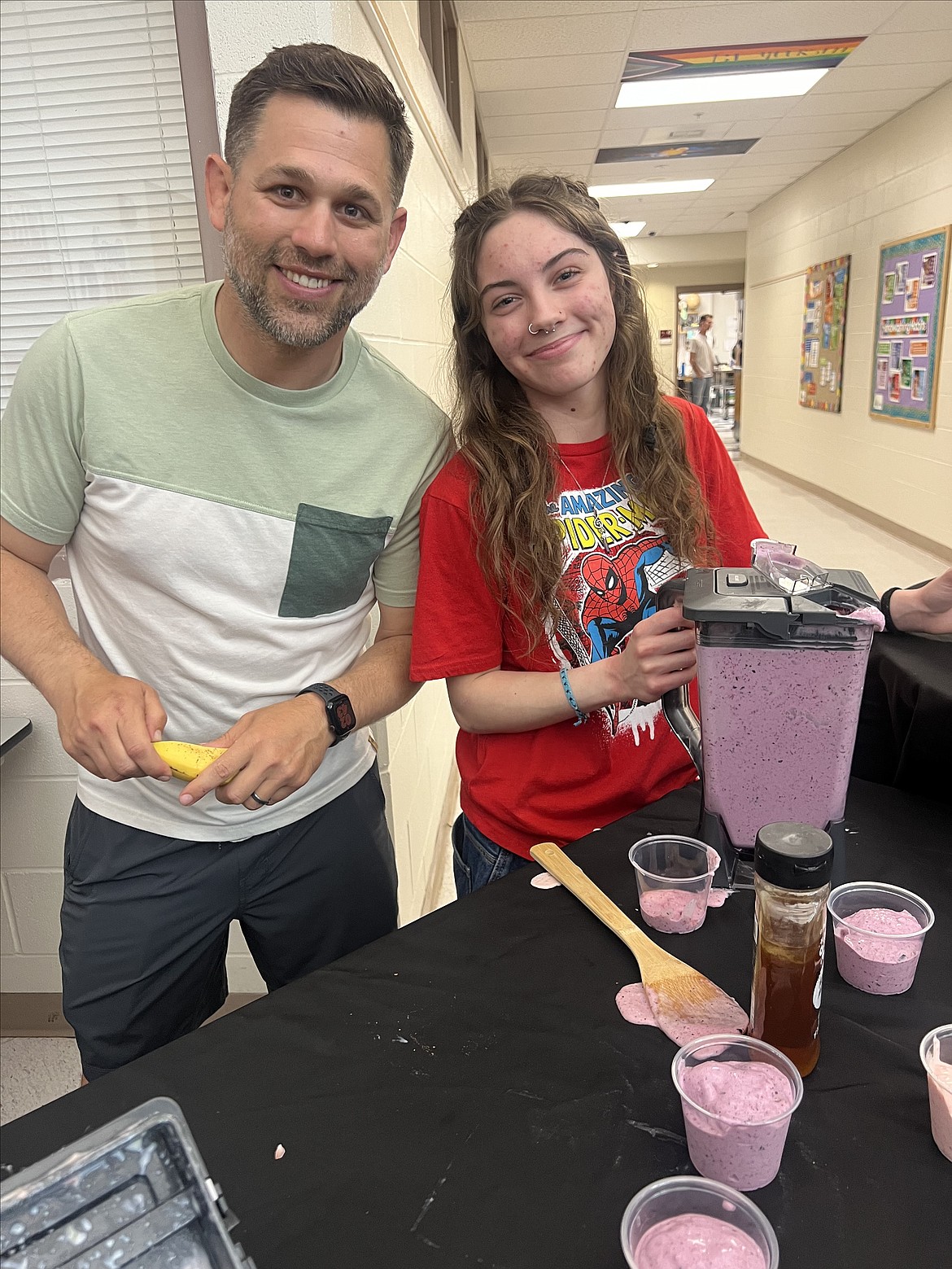 Sophomore Shianne Zulas leads the smoothie and infused water station Wednesday evening along with health teacher Tony Hook during Venture Academy's Exhibit Night.