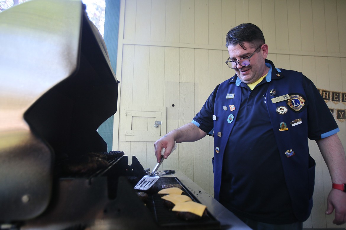 First Vice President and Lion of the Year Joel Nelson mans the grill Wednesday during the Post Falls Lions Club's 60th anniversary celebration and installation of officers, held in the Lions Grand Pavilion in Q'emiln Park.