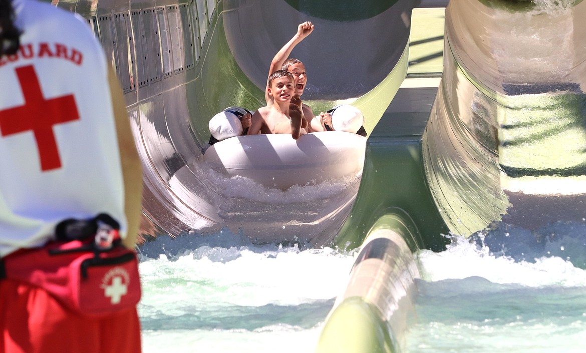 Andrew Pappas smiles and Darren Fruhwirth raises his fist in triumph after they were the first riders to finish Eagle Hunt, the new water roller coaster at Silverwood Theme Park on Saturday.