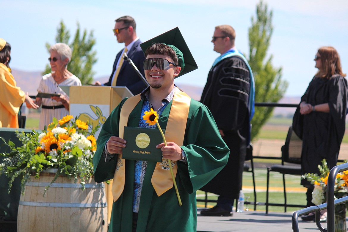 A brand-new Quincy High School graduate shows off his diploma.