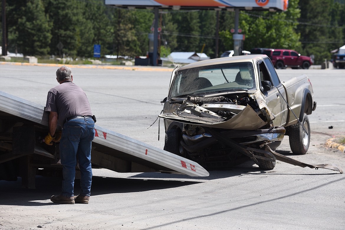 A South End Towing driver prepares to remove a pickup truck from the scene of a two-vehicle accident Saturday, June 8, on U.S. 2 near Bear's Country Store. (Scott Shindledecker/The Western News)