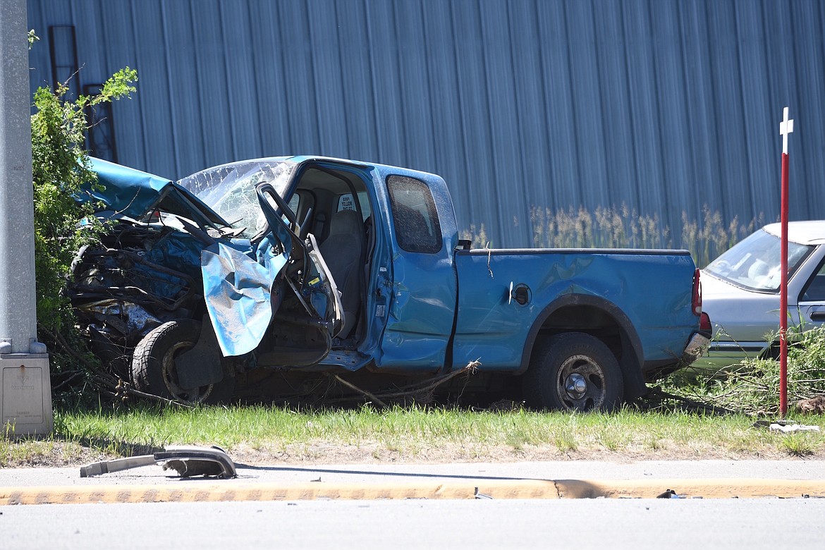 A blue Ford pickup truck sits off U.S. 2 after being involved in a two-vehicle accident Saturday, June 8, 2024, near Bear's Country Store. (Scott Shindledecker/The Western News)