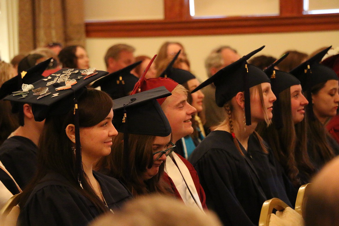 Forrest Bird High School graduates smile as they listen to a speech by teacher Mark Webber at Saturday's graduation.