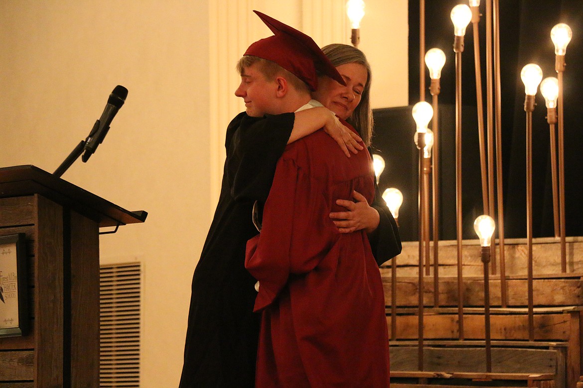 Forrest Bird Charter administrator Mary Jensen gives Karston Goodwin a hug after announcing he had earned academic excellence honors. The announcement was made at Saturday's FBCS graduatiion.