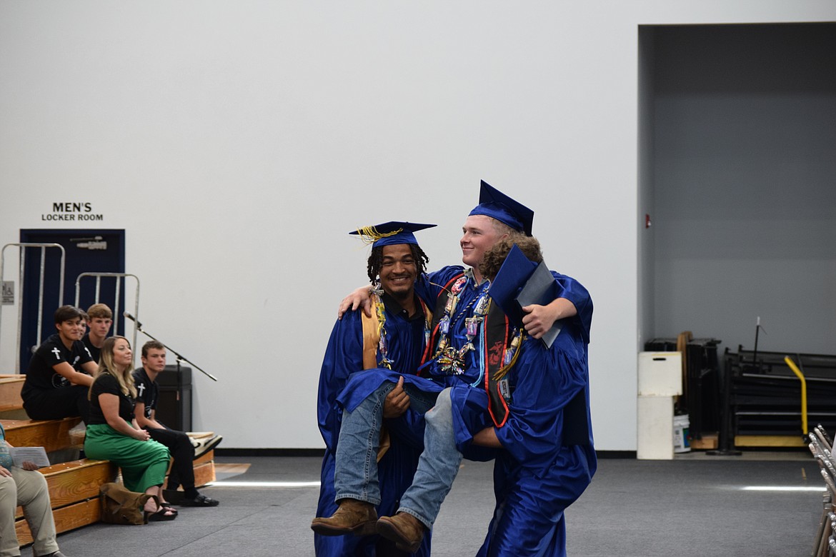 Caleb Jones, left, and Dennis Fountain, right, carry Jonah Robertson as the three move out into the foyer of The Den, MLCA’s gymnasium that hosted the commencement ceremony. Robertson is set to be a marine while Jones intends to attend Pacific NW Christian and Fountain will attend West Coast Baptist College.