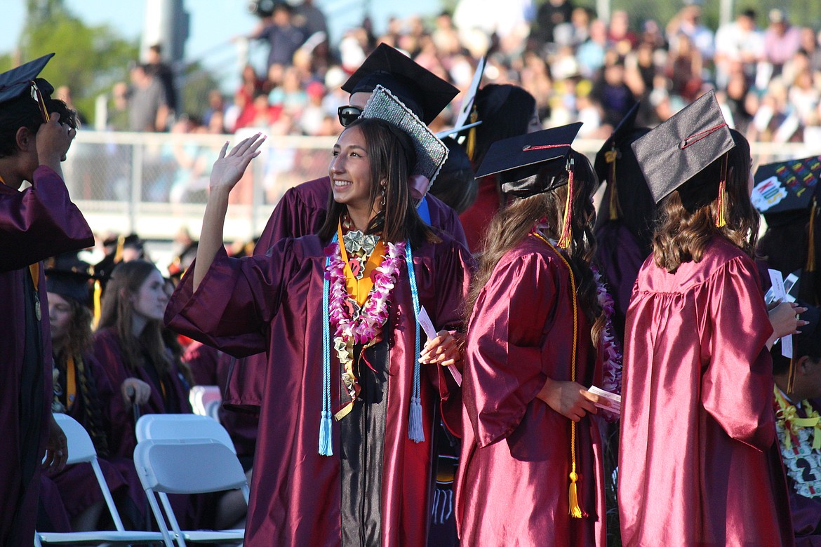 An MLHS graduate waves to family in the stands.