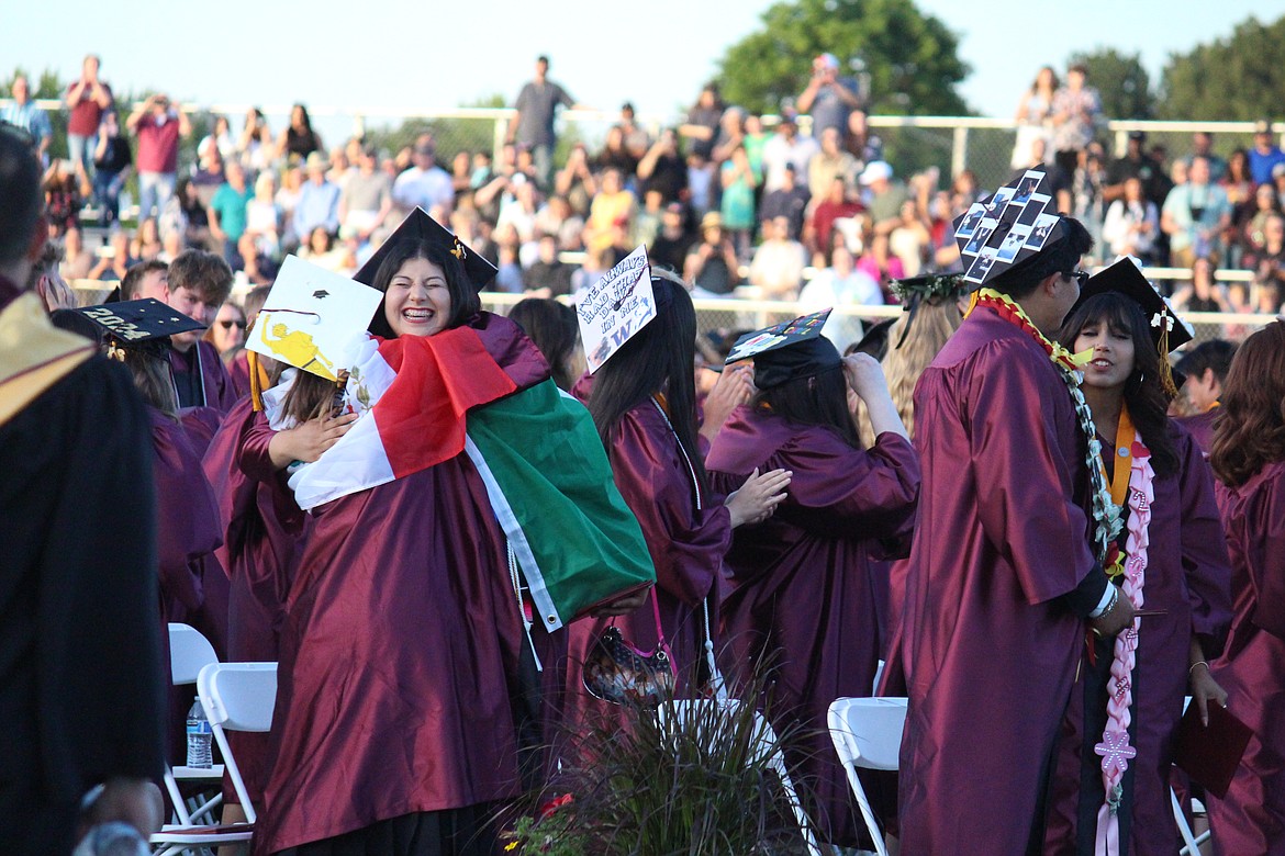 Graduation completed and tassels turned, Moses Lake seniors give each other a hug.