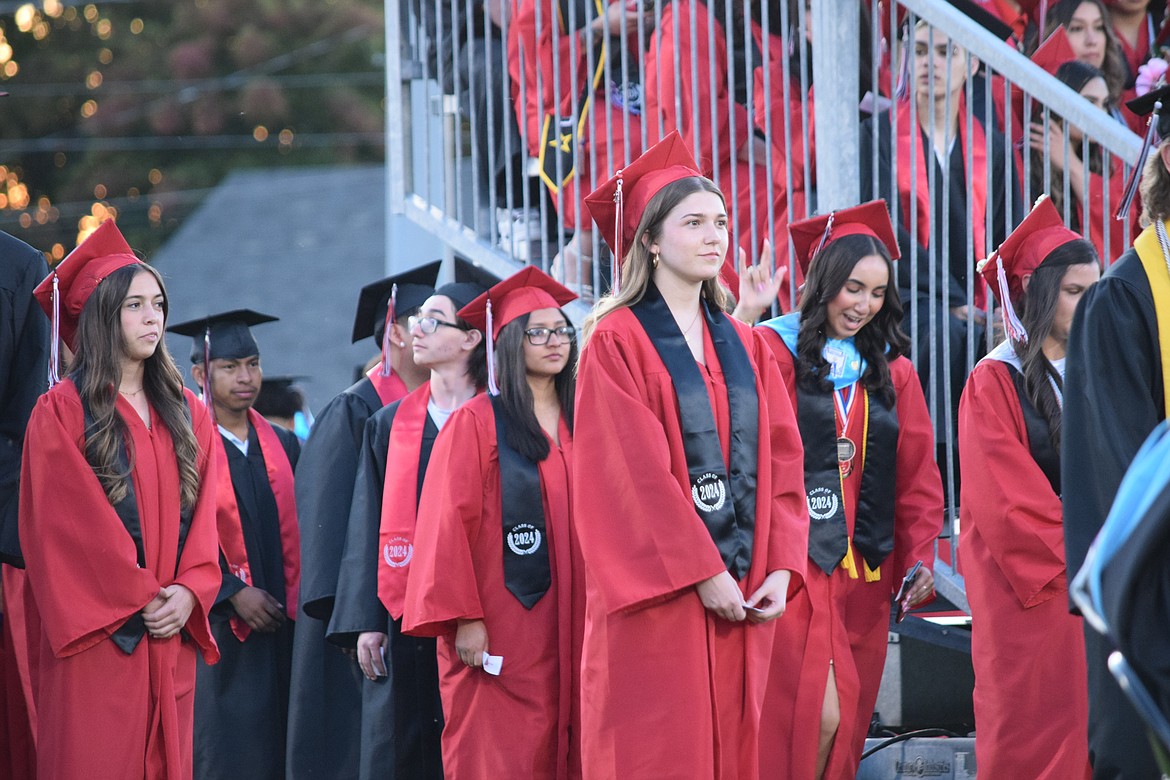 Othello High School graduating seniors line up behind the stage Friday evening on the field behind OHS, waiting to accept their diplomas.